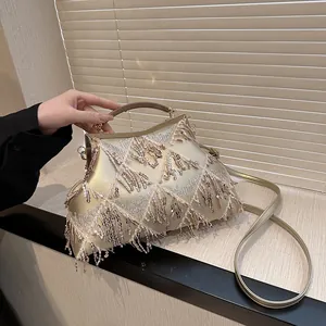 Dettaglio borsa da sera con paillettes oro champagne con frange e manico in metallo