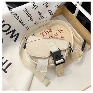 Dettaglio della mini borsa a tracolla in nylon beige con fibbia nera funzionale