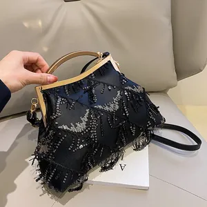 Elegante borsa da sera con paillettes nere, manico in metallo dorato e nappine