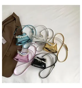 Dettaglio flat lay di mini borse a trapezio metalliche con manici di perle in cinque colori