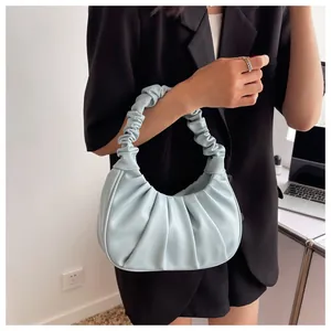 Detail of light blue pleated cloud bag showing soft leather texture and handle design