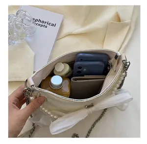 Vista interna della borsa con perle bianca che mostra la capienza per smartphone