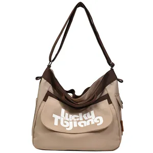 Grande borsa a tracolla in tela beige e marrone con scritta Lucky Tojiang e cinturino