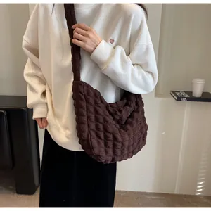 Détail du sac demi-lune marron foncé avec texture plissée et large bandoulière confortable