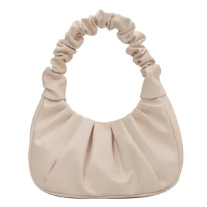 Close-up of the elegant scrunchie shoulder strap and pleated cream leather texture