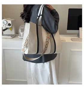 Détail du sac cabas en toile avec rayures verticales et bandoulières tissées style ethnique