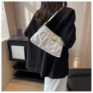 Dettaglio borsa sottobraccio plissettata bianca in pelle con fibbia dorata sulla spalla