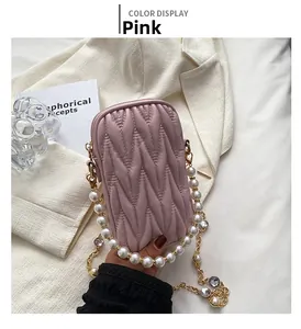 Detailed view of pink quilted cell phone bag with pearl and gold metal chain strap