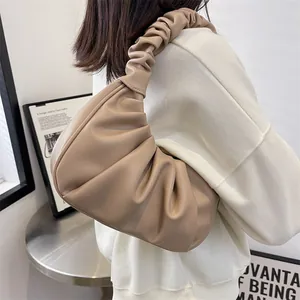 Minimalist beige ruched shoulder bag with a cloud-like pleated design and soft handle