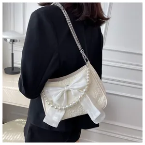 Dettaglio della borsa a tracolla jacquard bianco crema con fiocco in seta e catena di perle