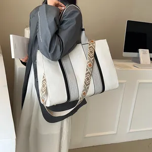 Grand cabas en toile blanche avec bandoulière à motifs et sangles noires pour le bureau