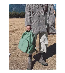 Dettaglio dello zaino in tela verde salvia con trama vintage e tasca laterale esterna