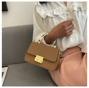 Detailed view of khaki leather handbag featuring gold-tone lock and precise stitching