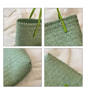 Detail view of woven texture and green leather handles with golden rivets on tote bag
