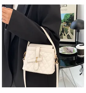 Dettaglio borsa a secchiello bianca in pelle trapuntata con manico e tracolla regolabile