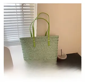 Detail showing woven light green tote texture with faux leather handles and gold rivets