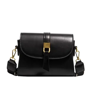 Minimalist black faux leather crossbody bag with elegant gold metal buckle and wide strap
