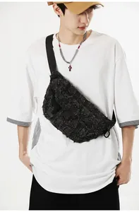Detailed view of black distressed tweed texture and nylon strap on crossbody bag
