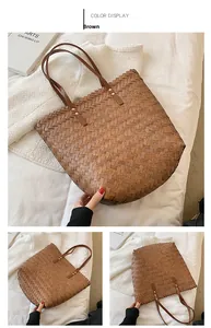 Detail of a brown woven tote bag with leather handles and gold studs on a white fabric