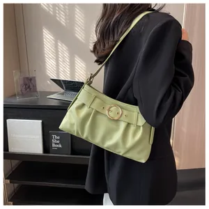 Dettaglio della borsa a spalla verde chiaro arricciata con fibbia in metallo dorato