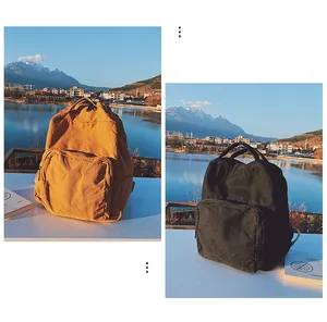 Coppia di zaini in tela gialla e nera dal design minimalista in uno scenario naturalistico