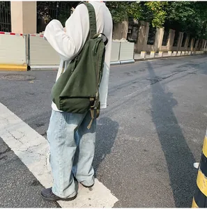 Primer plano de la textura de lona verde oscuro y la resistente correa ancha de la mochila