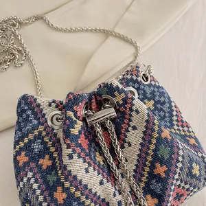 Dettaglio ravvicinato della borsa a secchiello etnica tessuta con catena argentata e coulisse