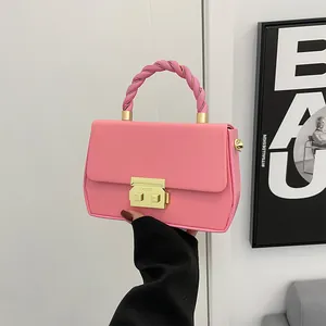 Pink faux leather handbag with twisted handle and gold metal buckle for women