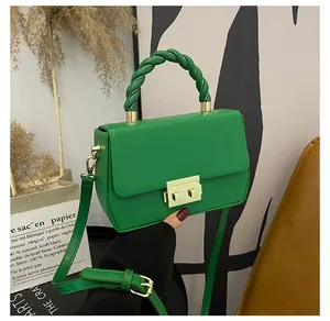 Minimalist green faux leather handbag with braided handle and golden buckle clasp