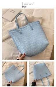 Close-up of light blue woven tote bag with leather texture and gold rivet details