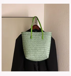 Detail of light green woven tote bag with bright green handles on a wooden hanger