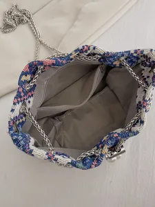 Dettagli interni della borsa a secchiello etnica con trama tessuta, chiusura con perla