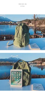 Zaino in tela verde salvia con scomparto principale e confronto misure per tablet