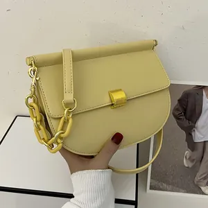 Borsa a sella beige alla moda con chiusura dorata e tracolla a catena in resina