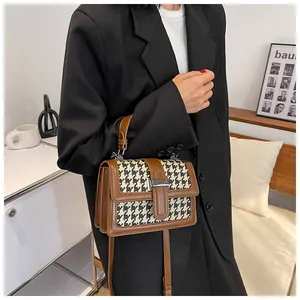 Modella che indossa una borsa a tracolla pied-de-poule vintage con finiture in pelle marrone