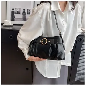Vista dettagliata della borsa nera a pieghe con una distintiva fibbia ad anello dorata grande