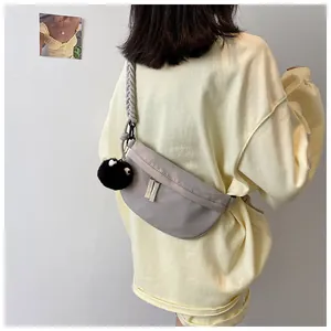Dettaglio borsa a mezzaluna in nylon grigio con tracolla a corda e charm in peluche