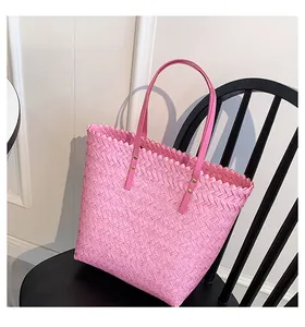 Detail of pink woven bucket bag texture with leather handle and gold rivet fastener