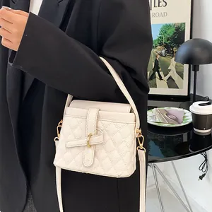 Elegante borsa trapuntata bianco crema con chiusura metallica in un ambiente urbano