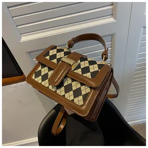 Dettaglio macro della borsa vintage a rombi con finiture in pelle marrone opaca