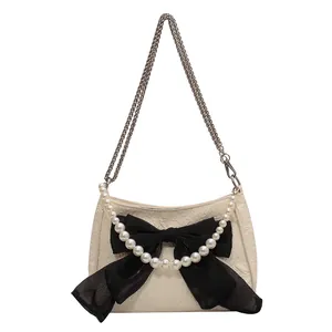 Borsa a tracolla bianco crema con fiocco nero, catena di perle e tracolla in metallo
