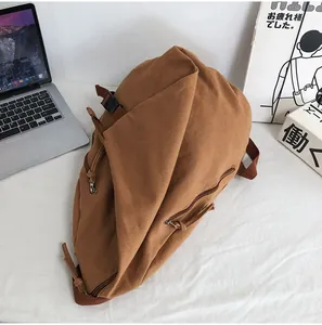 Detalle de mochila de lona marrón de gran capacidad con cremallera lateral y cierre hebilla