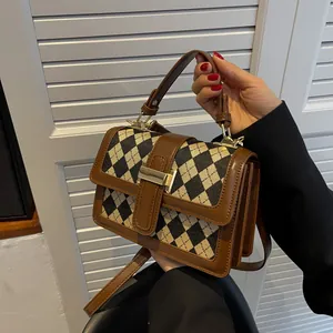 Borsa a tracolla pied-de-poule marrone e nera con chiusura dorata e manico superiore