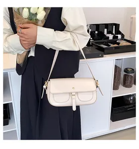 Dettaglio di una borsa baguette crema minimalista con cuciture e chiusura a patta