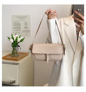 Dettaglio della borsa sottobraccio beige in ecopelle con doppie tasche e tracolla