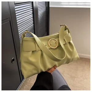 Dettaglio della borsa a pieghe verde pistacchio con fibbia dorata e trama in pelle liscia