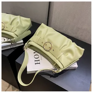 Dettaglio della texture arricciata della borsa verde chiaro con fibbia dorata