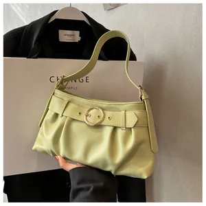 Dettaglio della borsa a pieghe verde chiaro con grande fibbia dorata rotonda