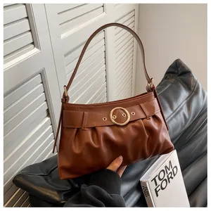 Dettaglio della borsa a tracolla marrone con fibbia dorata e design a pieghe