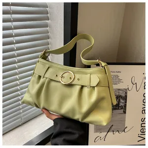 Dettaglio della borsa a spalla plissettata verde chiaro con fibbia dorata in pelle PU